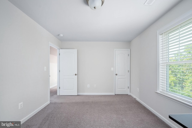 unfurnished room with light colored carpet