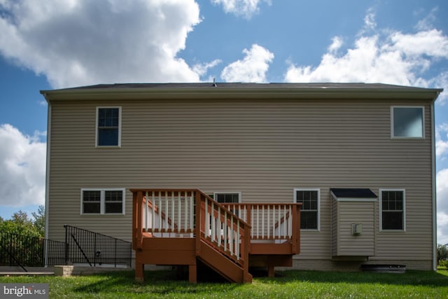 back of property with a wooden deck and a lawn