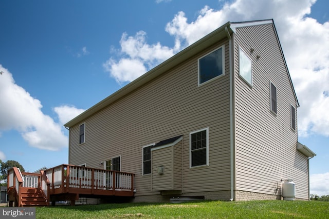 rear view of property featuring a yard and a deck