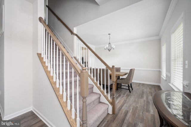 stairs featuring ornamental molding, a chandelier, hardwood / wood-style floors, and a wealth of natural light