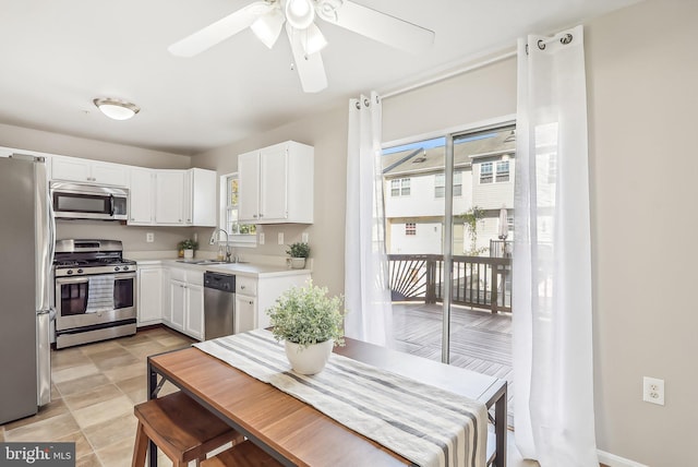 kitchen with ceiling fan, sink, white cabinets, and stainless steel appliances