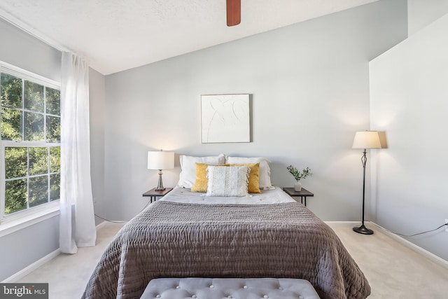 carpeted bedroom featuring ceiling fan, multiple windows, and vaulted ceiling