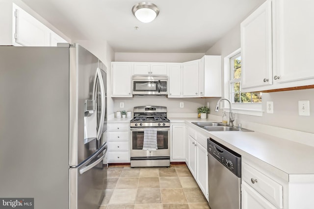 kitchen with sink, white cabinetry, light tile patterned floors, and stainless steel appliances