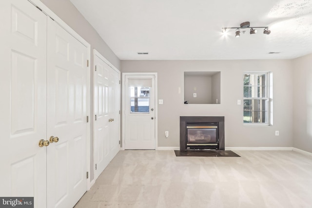 unfurnished living room with light colored carpet