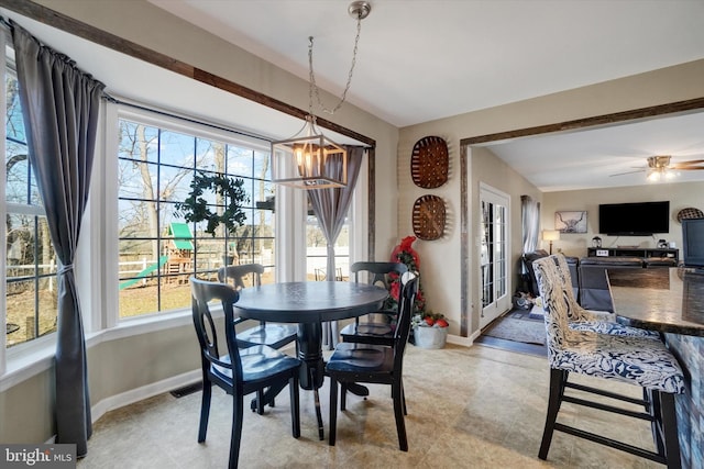 dining area featuring ceiling fan with notable chandelier