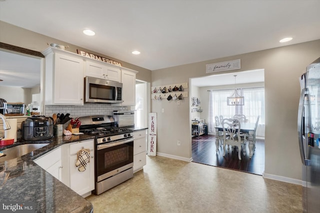 kitchen featuring sink, tasteful backsplash, hanging light fixtures, appliances with stainless steel finishes, and white cabinets