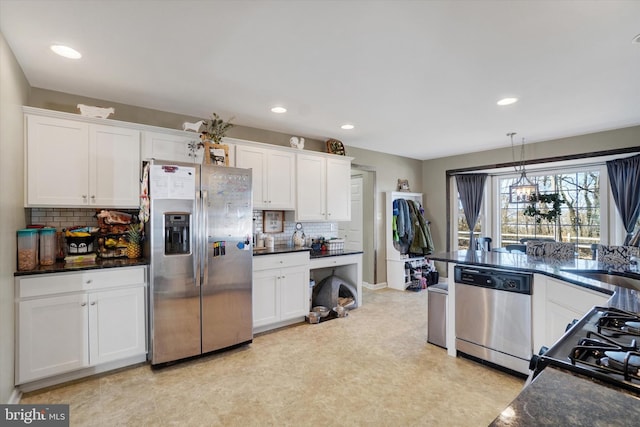 kitchen featuring white cabinetry, appliances with stainless steel finishes, and hanging light fixtures