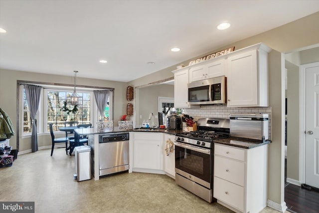 kitchen featuring sink, hanging light fixtures, backsplash, stainless steel appliances, and white cabinets