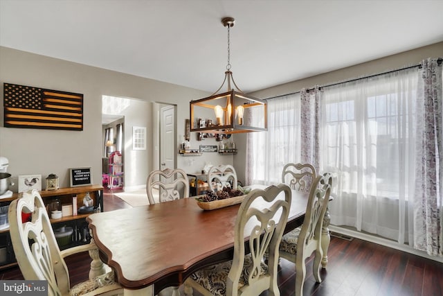 dining room with dark hardwood / wood-style floors and an inviting chandelier