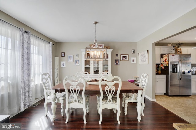 dining area featuring an inviting chandelier and dark hardwood / wood-style flooring