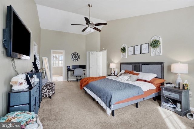 carpeted bedroom with ceiling fan and high vaulted ceiling