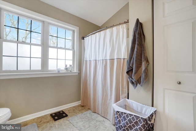 bathroom featuring lofted ceiling, tile patterned floors, and toilet