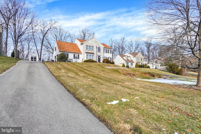 cape cod home featuring a front yard