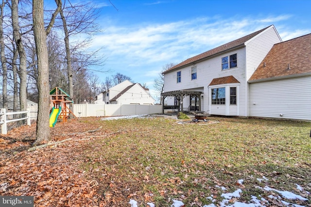 back of property featuring a pergola, a lawn, and a playground