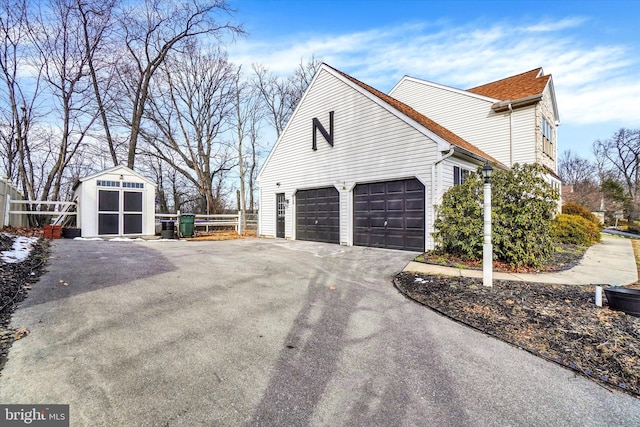 view of side of property featuring a garage and a storage shed