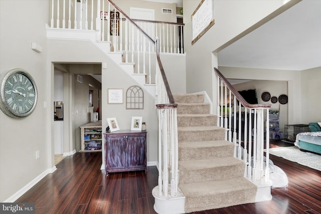 stairway featuring hardwood / wood-style flooring and a high ceiling