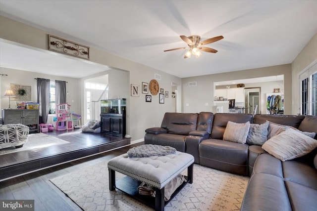 living room featuring wood-type flooring and ceiling fan