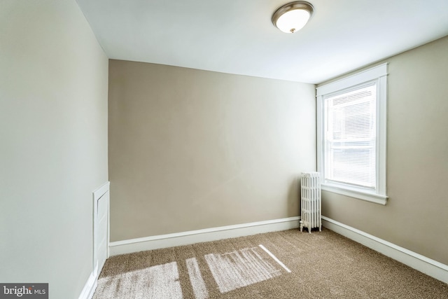 carpeted empty room with radiator heating unit and plenty of natural light