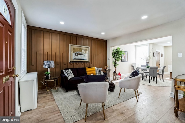 living room featuring wooden walls and light hardwood / wood-style flooring