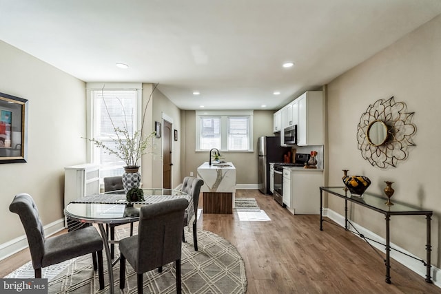 dining space featuring sink and hardwood / wood-style floors