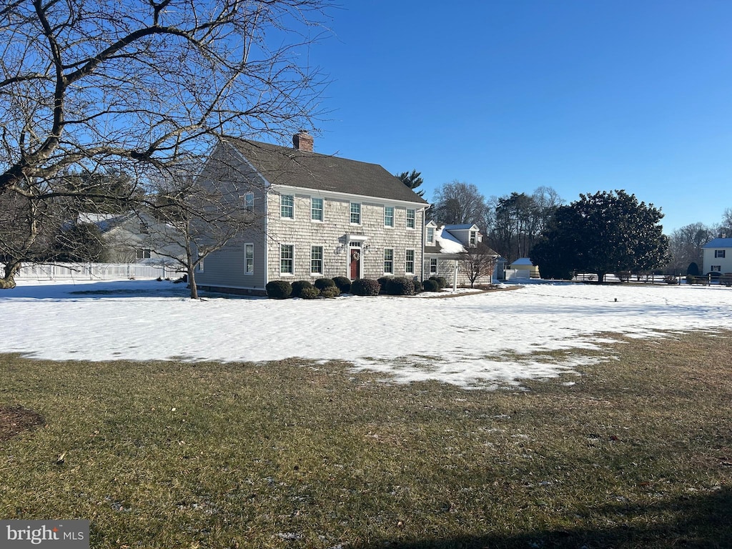 snow covered rear of property with a lawn