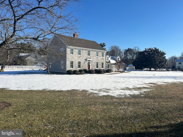 snow covered property with a yard