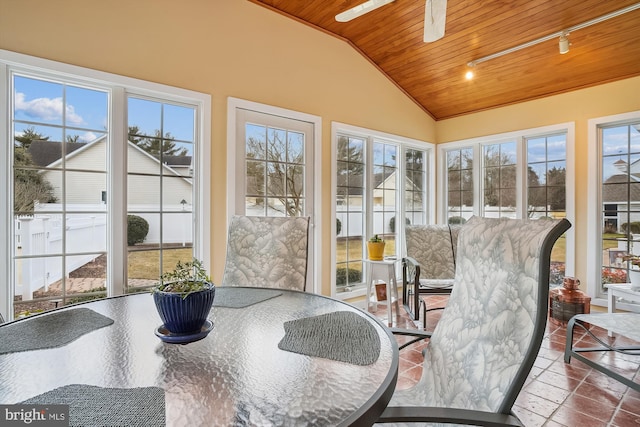 sunroom with wood ceiling, vaulted ceiling, rail lighting, and a healthy amount of sunlight