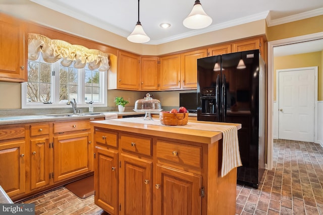 kitchen with crown molding, black fridge, sink, and decorative light fixtures