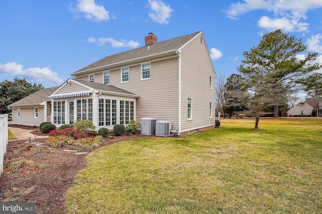 back of property featuring a sunroom, a yard, and central AC unit