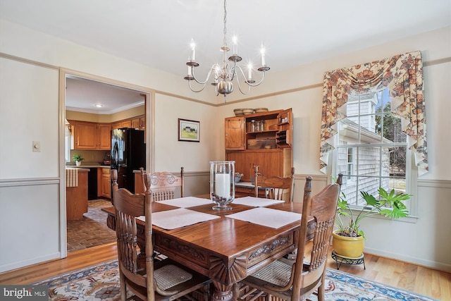 dining area featuring ornamental molding, a chandelier, and light wood-type flooring