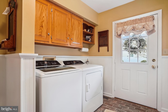 clothes washing area featuring cabinets and washing machine and clothes dryer