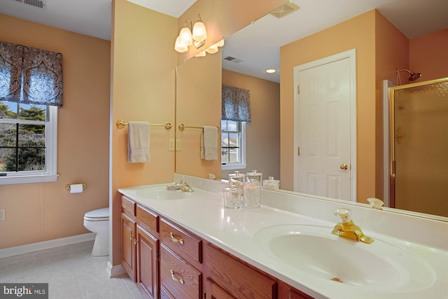 bathroom featuring tile patterned floors, toilet, a shower with door, and vanity