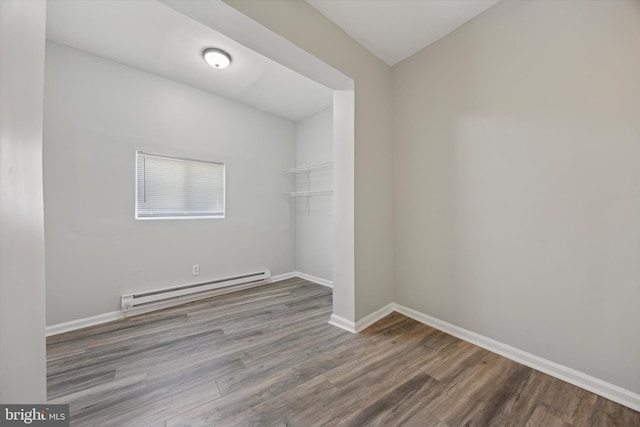 spare room with a baseboard radiator and wood-type flooring