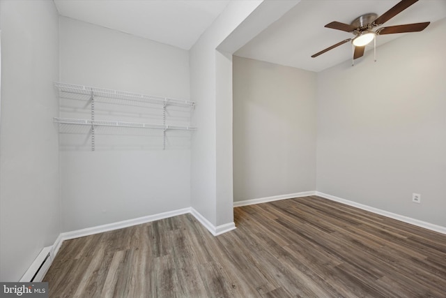 spacious closet with a baseboard heating unit, hardwood / wood-style flooring, and ceiling fan