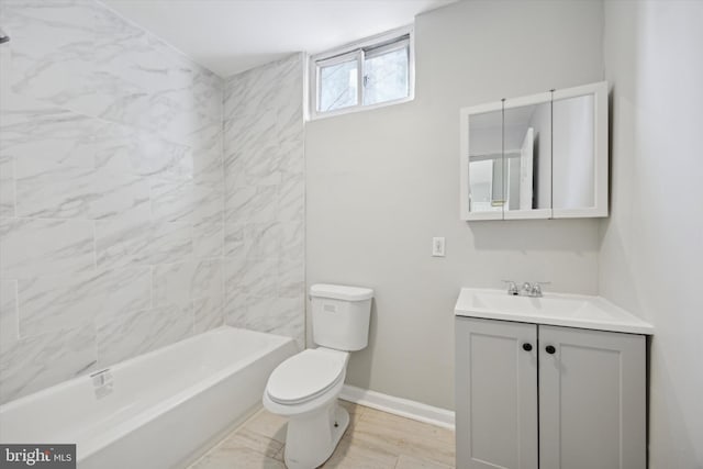 full bathroom featuring tiled shower / bath, vanity, and toilet