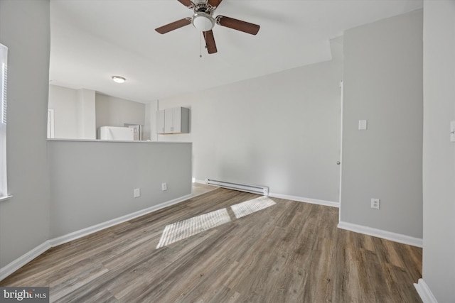 empty room featuring hardwood / wood-style flooring, a baseboard heating unit, and ceiling fan