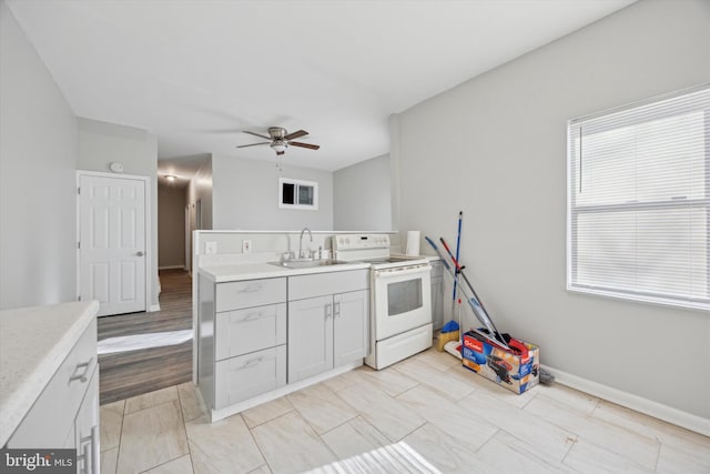 kitchen featuring sink, white electric stove, and ceiling fan