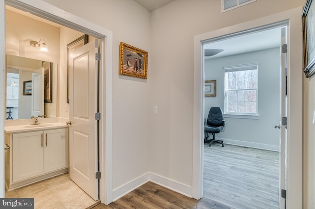 hall featuring sink and light wood-type flooring