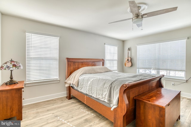 bedroom with multiple windows, light hardwood / wood-style floors, and ceiling fan