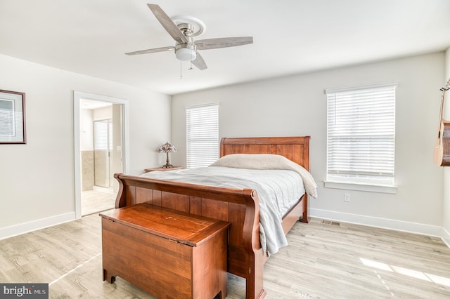 bedroom featuring ceiling fan, ensuite bath, and light hardwood / wood-style floors