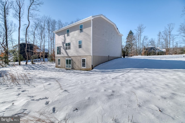 view of snow covered rear of property