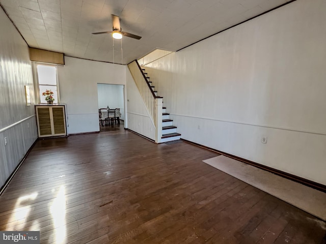 unfurnished living room featuring dark wood-type flooring and ceiling fan