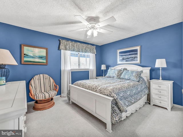 carpeted bedroom featuring a textured ceiling and ceiling fan