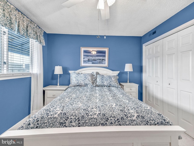 bedroom with ceiling fan, a closet, and a textured ceiling