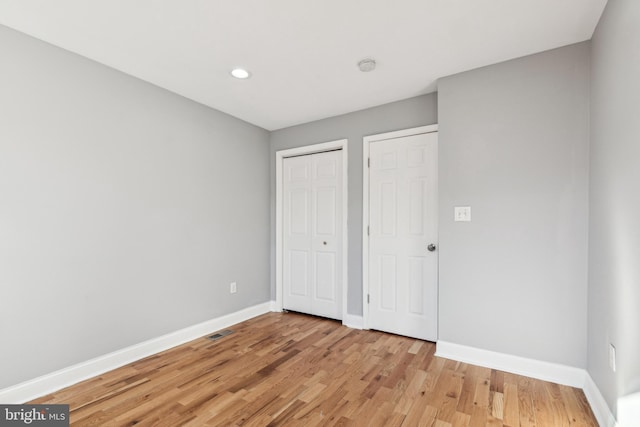 unfurnished bedroom featuring light hardwood / wood-style floors and a closet