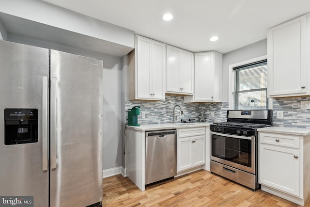 kitchen featuring light hardwood / wood-style floors, white cabinetry, stainless steel appliances, and sink