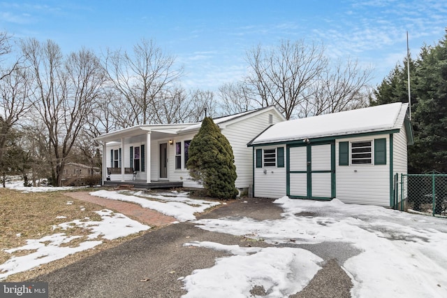 ranch-style home with an outbuilding and covered porch