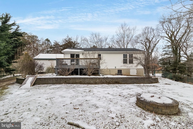 snow covered property featuring a deck and a fire pit