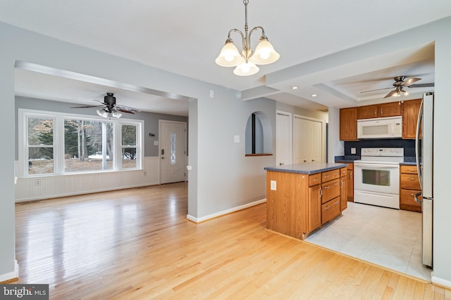 kitchen featuring hanging light fixtures, light wood-type flooring, white appliances, ceiling fan with notable chandelier, and a center island