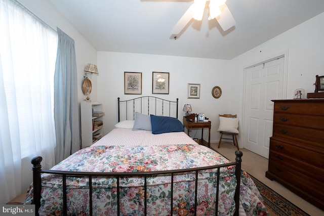 carpeted bedroom featuring ceiling fan and a closet